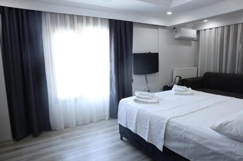 a bedroom with a large white bed and a window at lamoza in Narlıdere