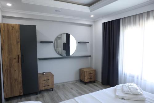 a white bedroom with a mirror and a bed at lamoza in Narlıdere