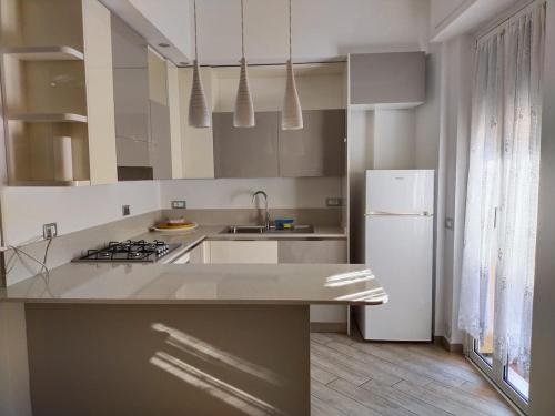 a white kitchen with a sink and a refrigerator at A&V Apartment in Santa Margherita Ligure