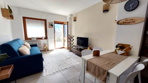 a living room with a blue couch and a table at Maison Golosamente alloggio comodo e accogliente con garage in Aosta