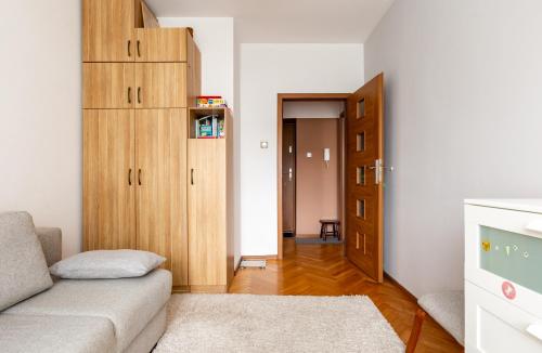 un soggiorno con divano e mobile in legno di Marina Harmony Apartment by BookingHost a Gdynia