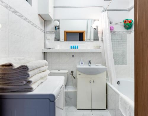 un bagno bianco con lavandino e specchio di Marina Harmony Apartment by BookingHost a Gdynia