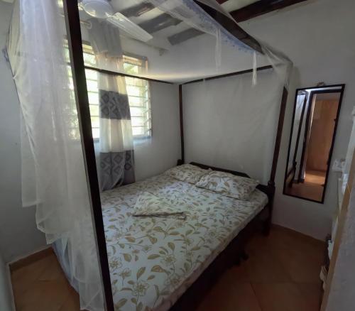 a small bed in a room with a window at Hakuna Matata in Ukunda