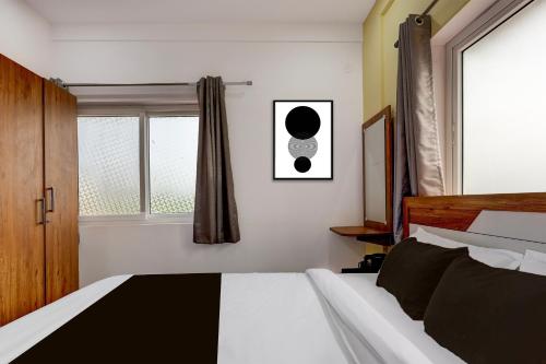 a bedroom with a black and white bed and a window at Collection O Lorven Grand in Visakhapatnam
