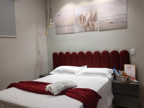 a bedroom with a large bed with a red headboard at Suíte Luxo na Casa 68 in Belém