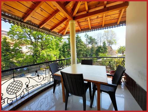 a table and chairs on a balcony with a view at Hotel Sapphire Stay- A Luxury Resort with All Room Attached Balcony and Valley View - Wifi - Restaurant - Parking and Children Play Ground Available - Best Resort in Nainital in Nainital