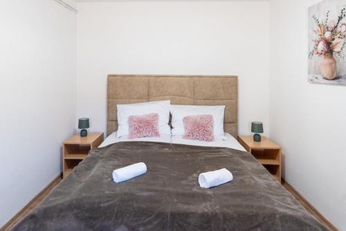 a bedroom with a large bed with pink pillows at Kuća za odmor Mali vikend u Vukovaru in Vukovar