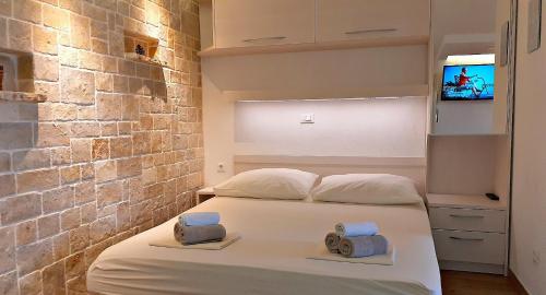 a bedroom with a bed with towels on it at Stone House Bonaca with Sea View in Baška Voda