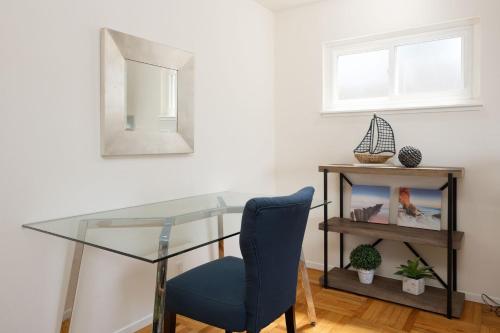 a glass table with a blue chair and a mirror at Entire Oceanview Coastal Retreat in Pacifica in Pacifica