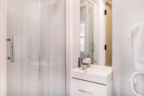 a white bathroom with a sink and a shower at 5 Ensuite Bed Apartment in Prime Location in Nottingham