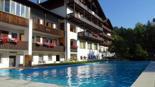 a hotel with a swimming pool in front of a building at Residence Perwanger in Völs am Schlern