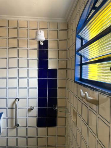 a bathroom with a tiled shower with a window at Hotel do Baú in Santa Rosa de Viterbo