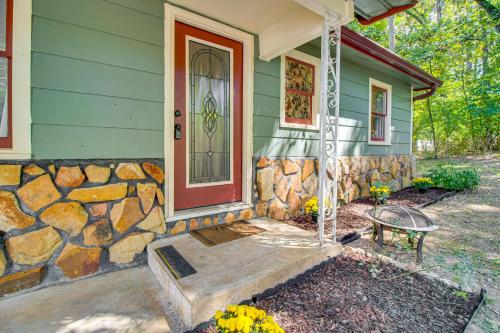 a green house with a stone wall and a door at Near State Park and Spring River Family Gem with Yard in Mammoth Spring