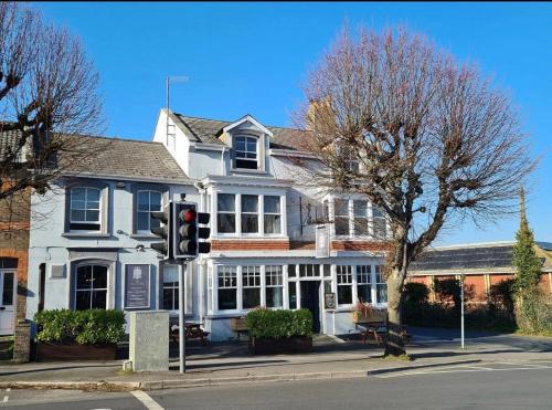 a traffic light in front of a white building at The Sydney Arms in Dorchester