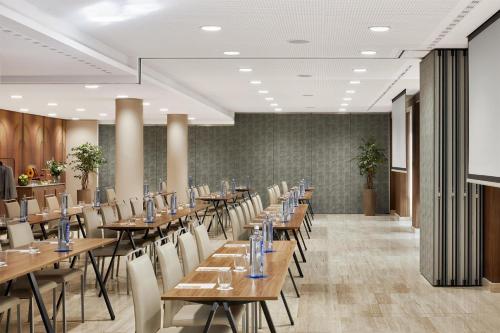 a conference room with wooden tables and chairs at NH Madrid Nacional in Madrid