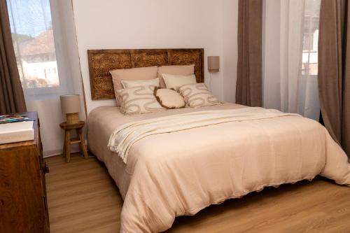 a bedroom with a large bed with pillows at Le Manguier, Apartment & Spa in Oberhaslach