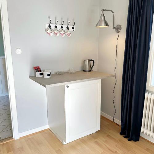 a kitchen with a white counter and a lamp at West wing, Långnäs Manor in Hofors