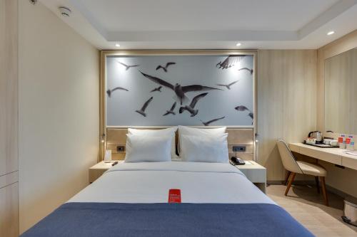 a bedroom with a bed with birds on the wall at Ramada by Wyndham Istanbul Old City in Istanbul