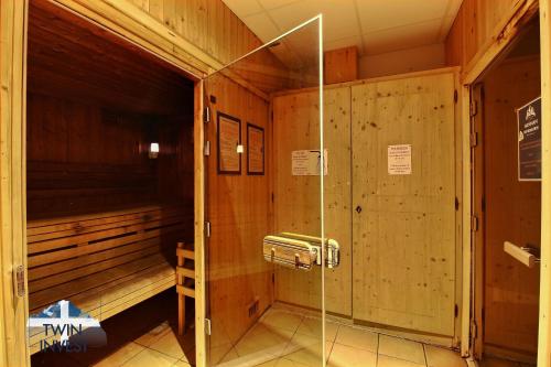 a sauna with a glass shower in a room at ARC 1950 - Appartement 6 personnes - Départ ski aux pieds - Sauna, Hammam, Jacuzzi, Piscine chauffée in Arc 1950