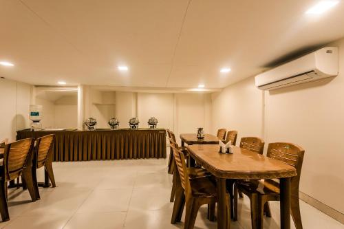 a dining room with a wooden table and chairs at Capital O Hotel Konar Inn in Turambhe