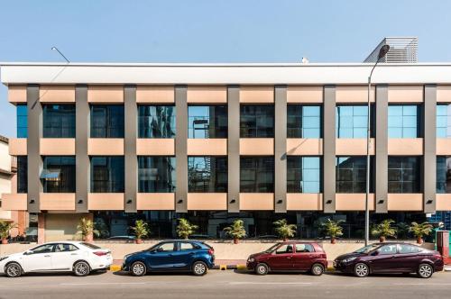 a building with cars parked in a parking lot at Capital O Hotel Konar Inn in Turambhe