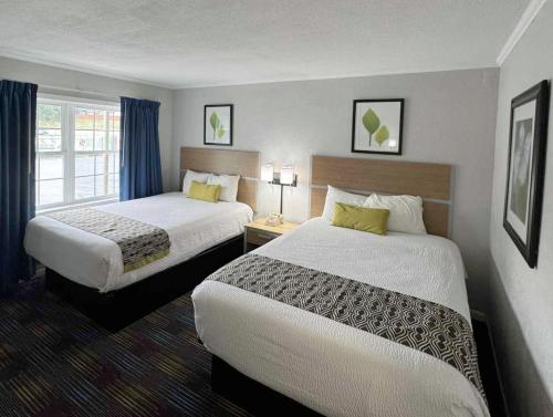 a hotel room with two beds and a window at Mountain Aire Inn Sevierville - Pigeon Forge in Sevierville