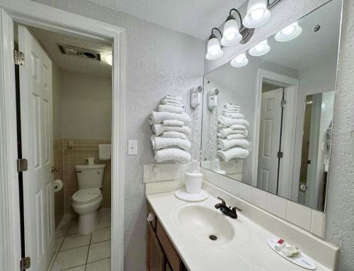 a bathroom with a sink and a toilet and a mirror at Mountain Aire Inn Sevierville - Pigeon Forge in Sevierville