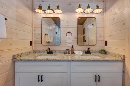 a bathroom with two sinks and two mirrors at Summit View By Avada Properties in Waldens Creek