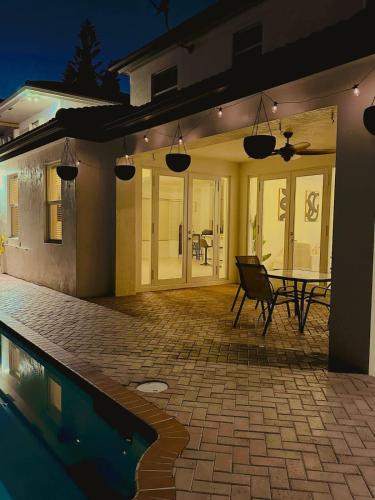 a house with a patio with a table and a pool at Miami home -15min from Kendall Exec Airport - Pool in Hammocks