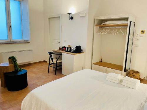 a bedroom with a white bed and a table at Casale Magrini Affittacamere in Fiamenga