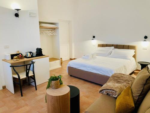 a bedroom with a bed and a table and a couch at Casale Magrini Affittacamere in Fiamenga