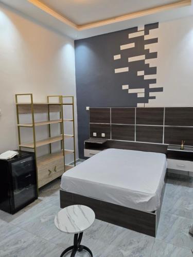 a bedroom with a bed and two stools in it at SUITE RESIDENCE TERANGAWALo in Richard Toll
