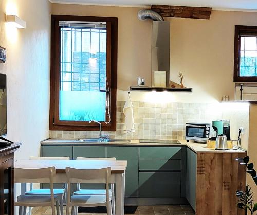 a kitchen with green cabinets and a table and chairs at Paloma13 in Ferrara