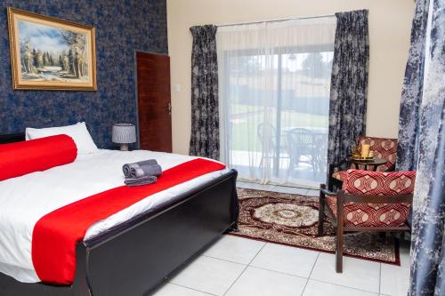 a bedroom with a large bed and a window at Nkoyoyo Cottage Retreat in Mbabane