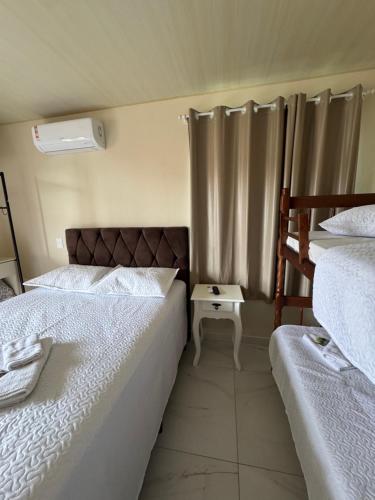 a bedroom with two twin beds and a window at Residencial Lara 5 in Itapema