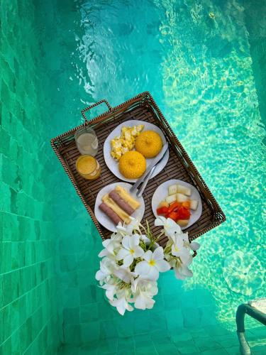 a tray of food on a table next to a swimming pool at Milagres de Minas in São Miguel dos Milagres