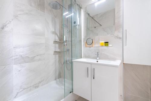 ニコシアにあるSunny & Stylish City Centre Livingの洗面台とシャワー付きの白いバスルーム