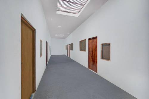 a corridor of a white room with a long hallway at SPOT ON Rs Hotel in Sītāpur