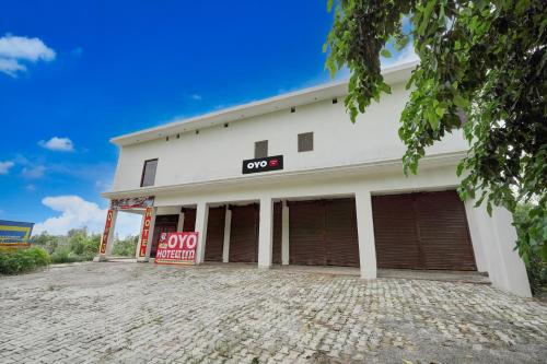 a white building with a sign on it at SPOT ON Rs Hotel in Sītāpur