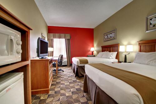 a hotel room with two beds and a flat screen tv at Holiday Inn Express Hurricane Mills Waverly by IHG in Hurricane Mills