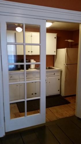 a kitchen with white cabinets and a window at Captain Hugo's Guesthouse in Rockland