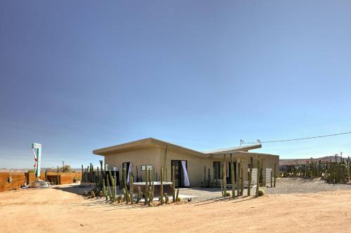 a building in the middle of a desert with cactus at Stargaze Escape By The Cohost Company in Yucca Valley