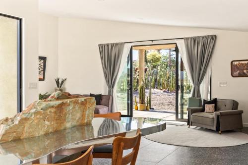 a living room with a couch and a glass table at Stargaze Escape By The Cohost Company in Yucca Valley