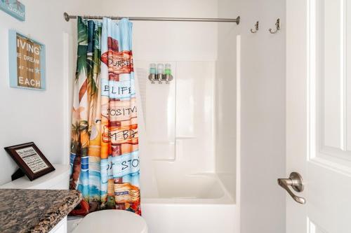 a bathroom with a shower curtain with a toilet at Welcome To Sarenity a 3Bd 2Bth home in Crystal Beach, Tx in Bolivar Peninsula