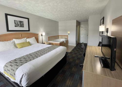 a hotel room with a bed and a flat screen tv at Mountain Aire Inn Sevierville - Pigeon Forge in Sevierville