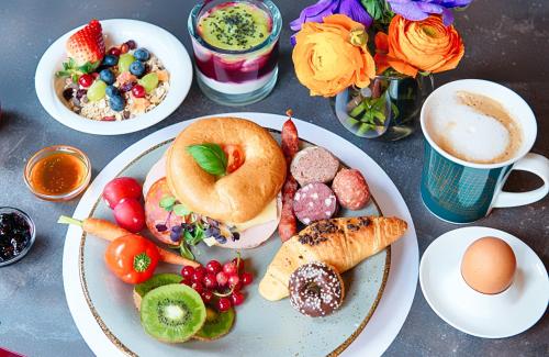 a table with plates of food and a cup of coffee at NYX Hotel Mannheim by Leonardo Hotels in Mannheim