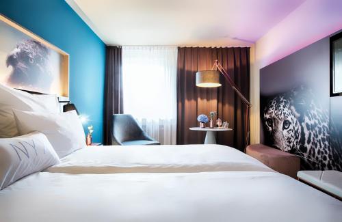 a hotel room with a white bed and a window at NYX Hotel Mannheim by Leonardo Hotels in Mannheim