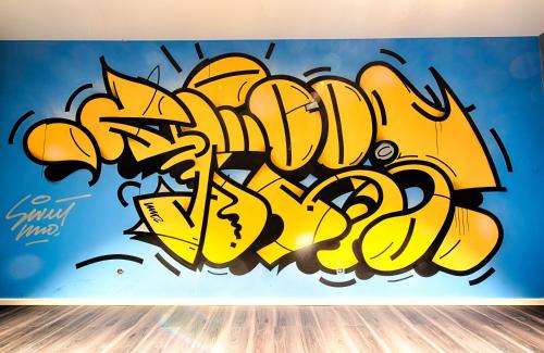 a room with a wall that has a wall covered in graffiti at NYX Hotel Mannheim by Leonardo Hotels in Mannheim
