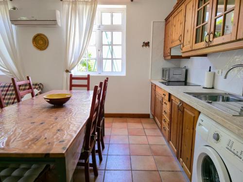 a kitchen with a wooden table and a sink at VV Casa Matilde "by henrypole home" in Valsequillo