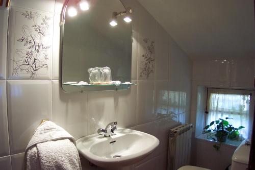 y baño con lavabo y espejo. en Hotel Rural La Pista en Vega de Rengos